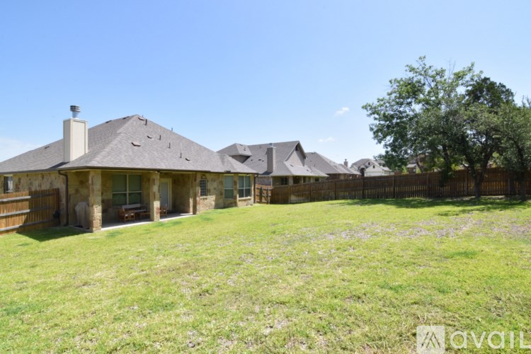 A house with a fence and a tree in the yard.