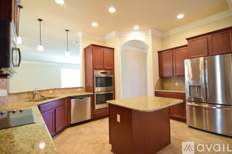 A kitchen with a granite countertop and stainless steel appliances.