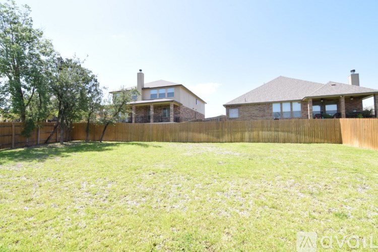 A house with a fence and a tree in the front yard.
