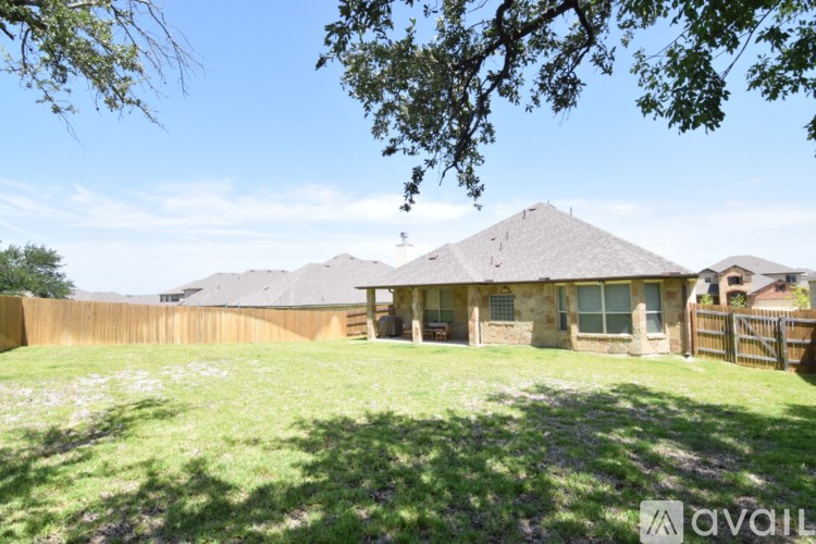 A house with a brown roof and a fence in front of it is available for sale.
