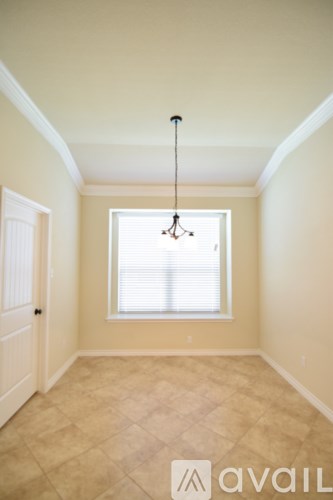 A room with a window and a chandelier.