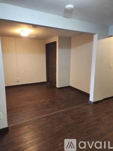 A room with wooden floors and a door in the middle.