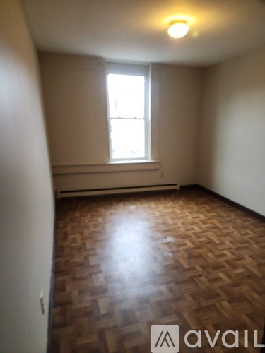 A room with wooden flooring and a window.
