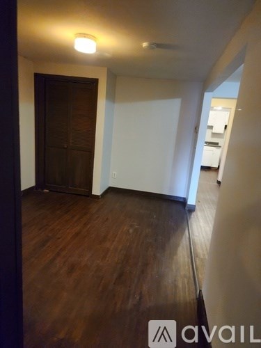 A room with wooden floors and a white wall.