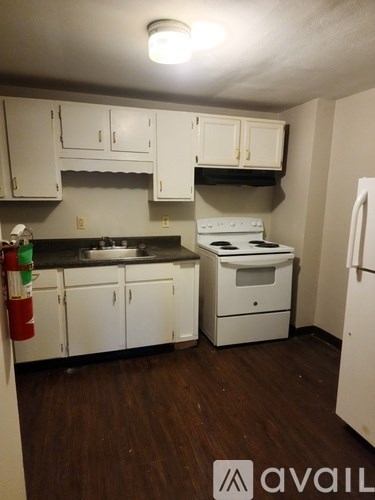 A kitchen with white appliances and cabinets.