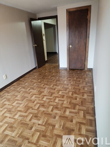 A hallway with a wooden floor and two doors.