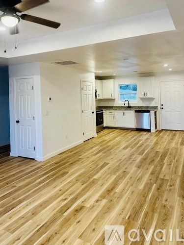 A kitchen with wooden floors and white walls.