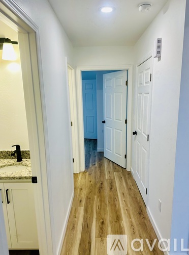 A hallway with a blue door and white walls.