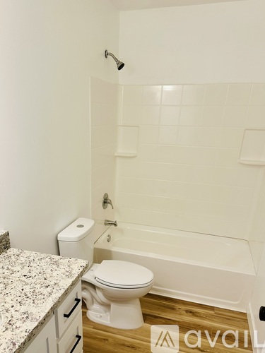 A white toilet sits next to a bathtub in a bathroom.