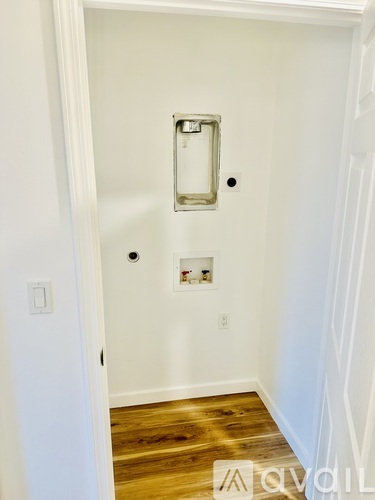 A white door with a silver handle and a small square mirror above it.
