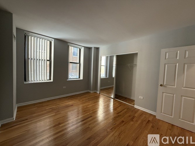 A spacious room with wooden floors and a white door.
