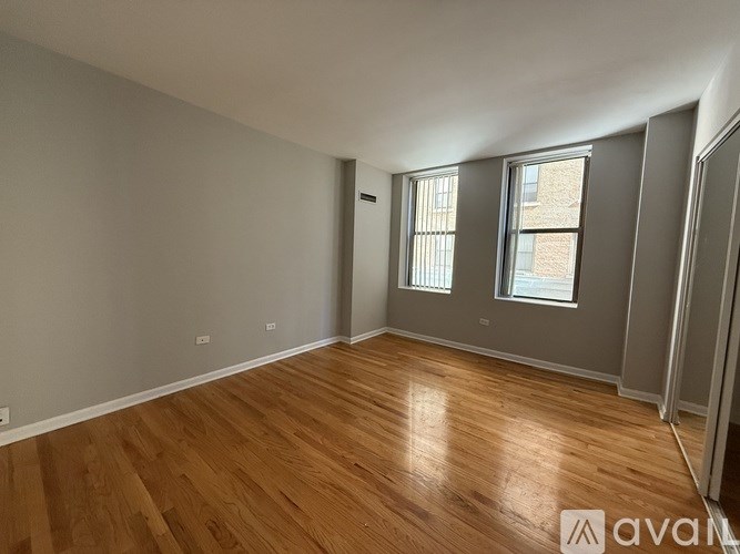 A room with wooden flooring and a window.