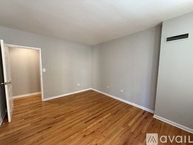 A room with wooden flooring and white walls.