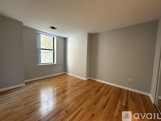 A room with wooden flooring and a window.