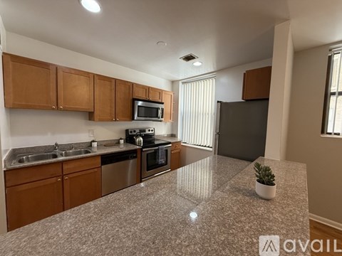 A kitchen with brown cabinets and a granite countertop.