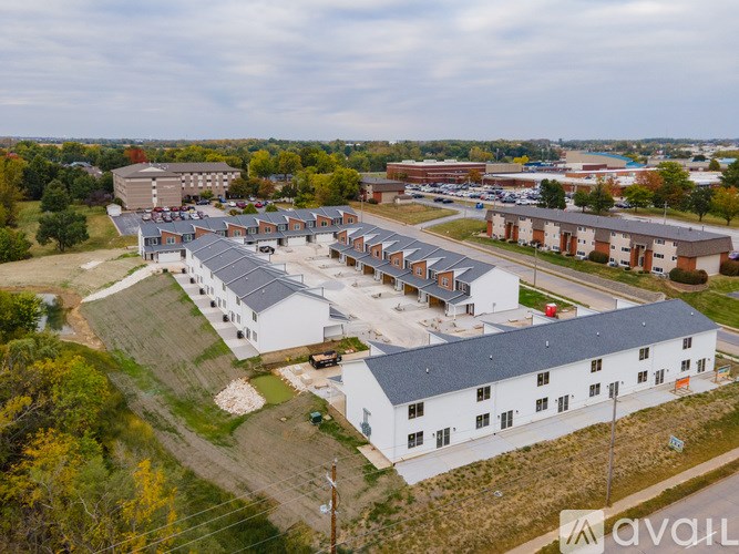 A large white building complex with a parking lot in front.
