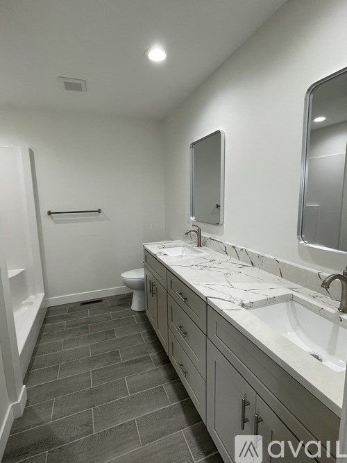 A bathroom with a toilet, sink, and mirror.
