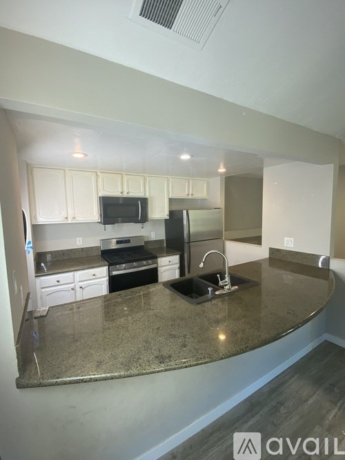 A kitchen with granite countertops and white cabinets.