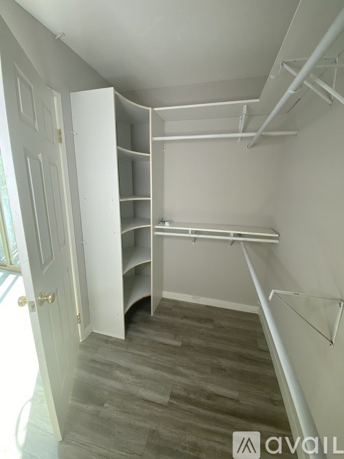 A white closet with shelves and a door open.
