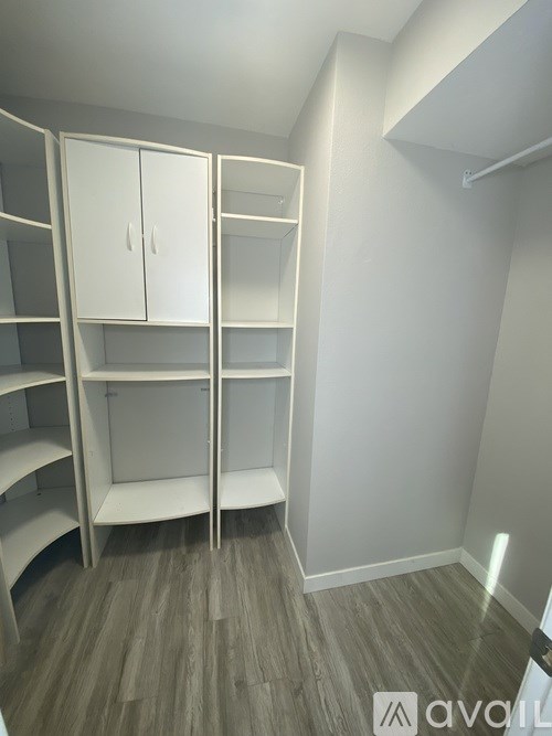 A room with white shelves and cabinets.