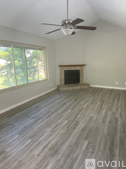 A room with a fireplace and a ceiling fan.