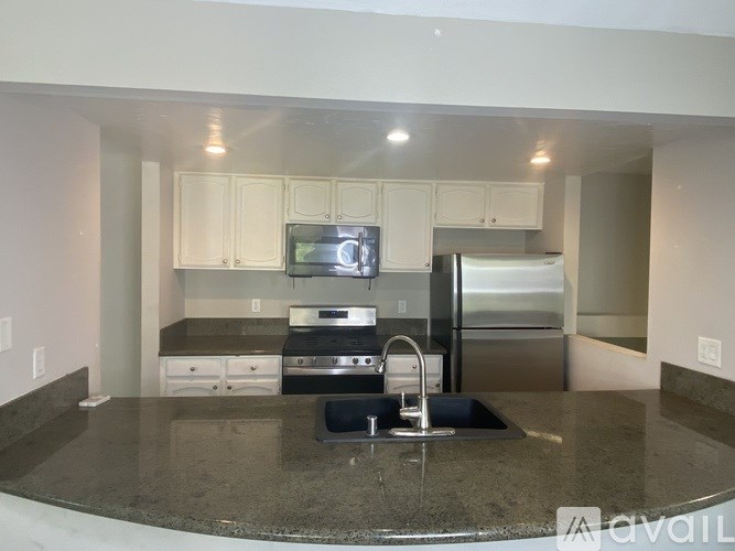 A kitchen with granite countertops and stainless steel appliances.