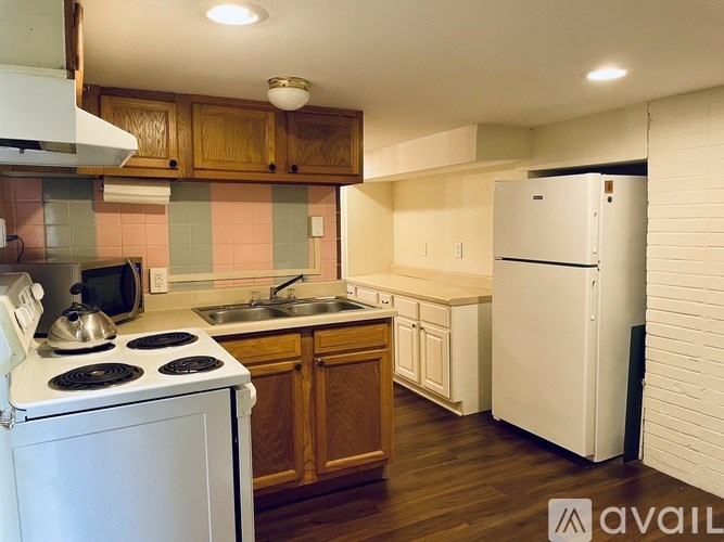 A kitchen with white appliances and wooden cabinets.