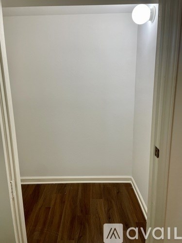 A room with wooden flooring and white walls.