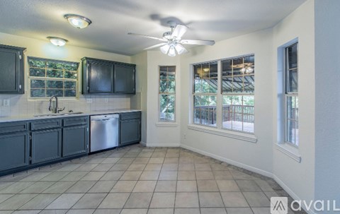 A kitchen with black cabinets and a silver dishwasher.