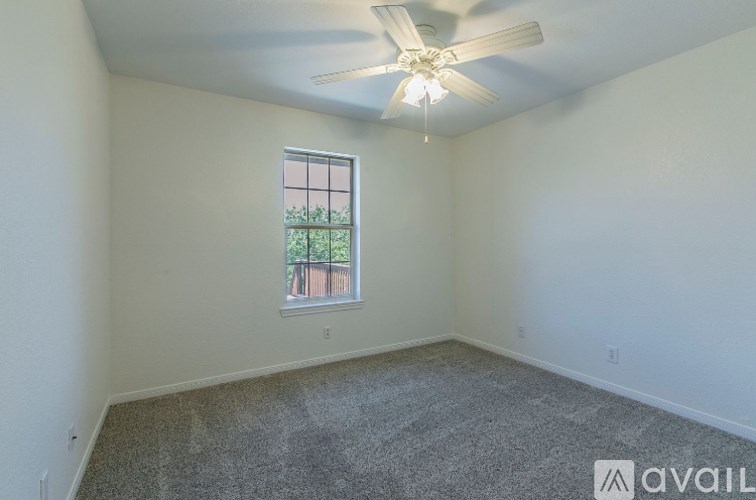 A room with a ceiling fan and a window.