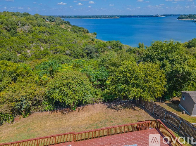 A view of a green hillside with a body of water in the distance.