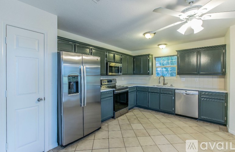 A kitchen with a white door and a stainless steel refrigerator.