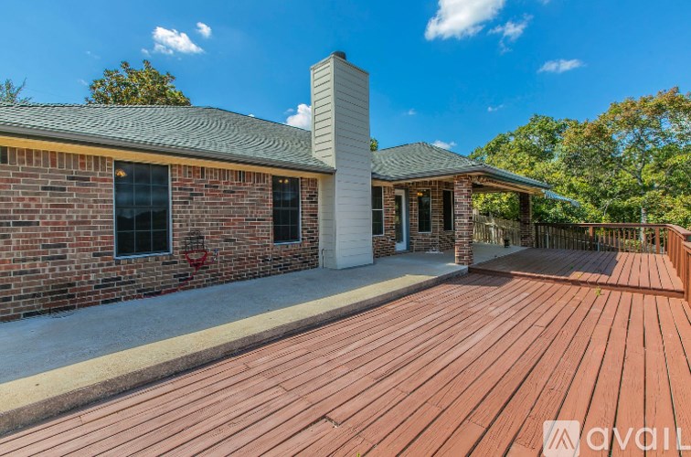A house with a red brick exterior and a wooden deck.