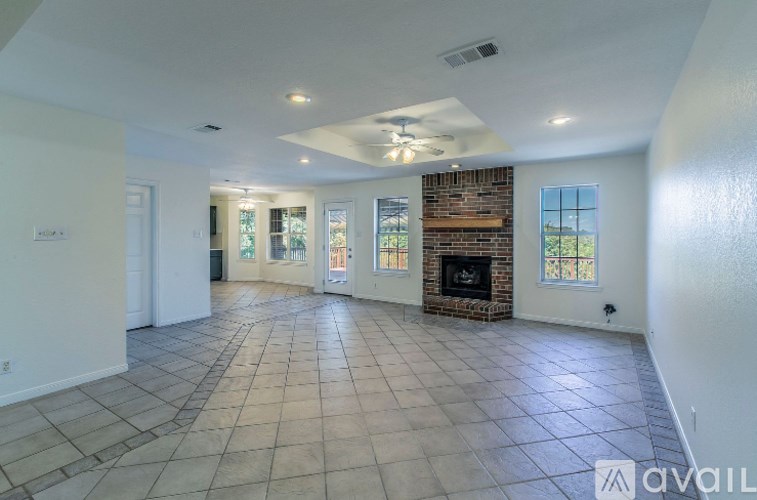 A spacious living room with a fireplace and tiled flooring.