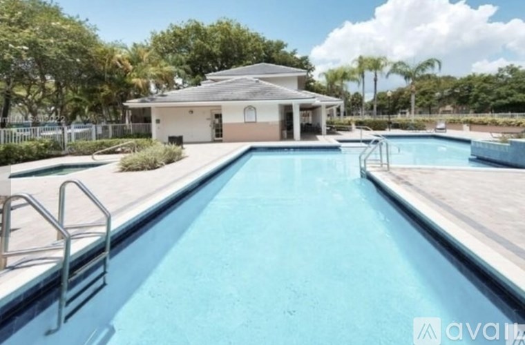 A swimming pool with a diving board and a building in the background.
