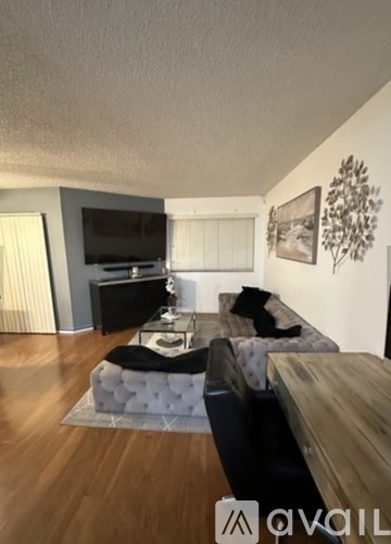 A living room with a couch, a coffee table, and a television.