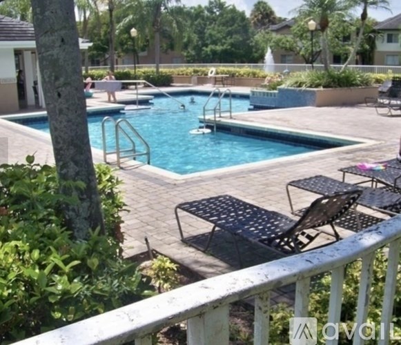A pool with a slide and a table and chairs around it.