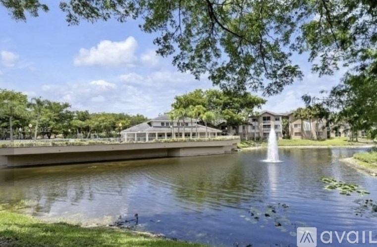 A serene park scene with a pond, a fountain, and a gazebo.
