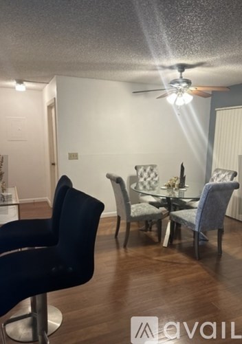 A room with a dining table and chairs.