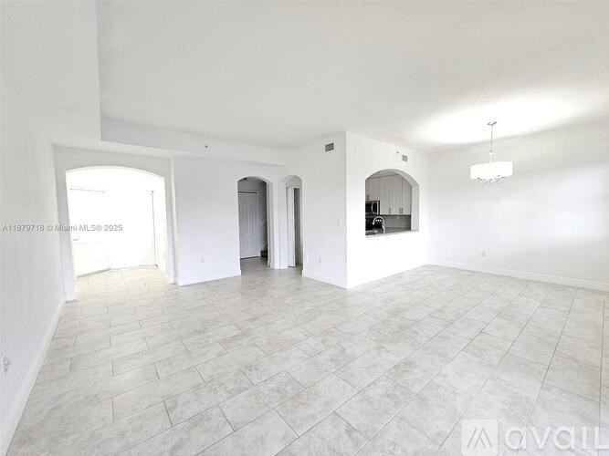 A spacious room with a tiled floor and white walls.