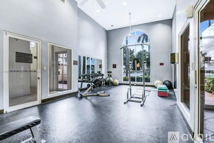 A spacious gym with a variety of equipment including a treadmill, weights, and a bench.