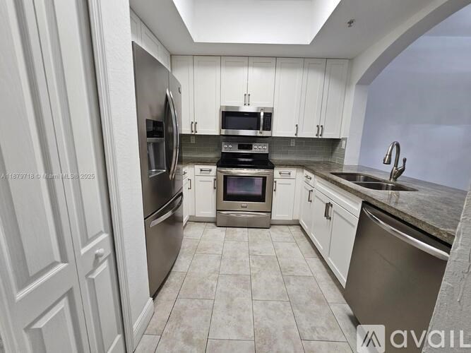 A kitchen with white cabinets and stainless steel appliances.