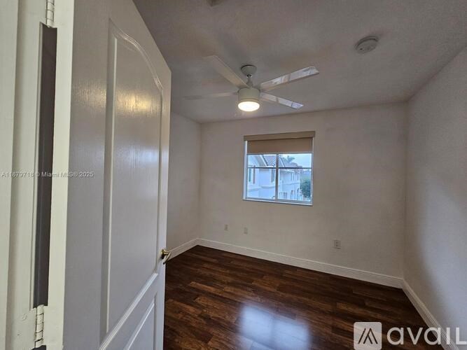 A room with a window and a ceiling fan.