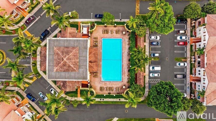 A bird's eye view of a resort with a swimming pool and parking lot.