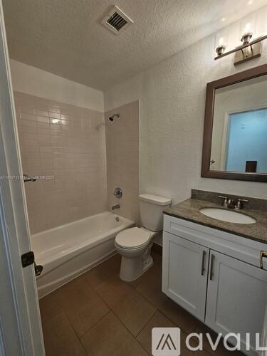 A bathroom with a toilet, sink, and bathtub.