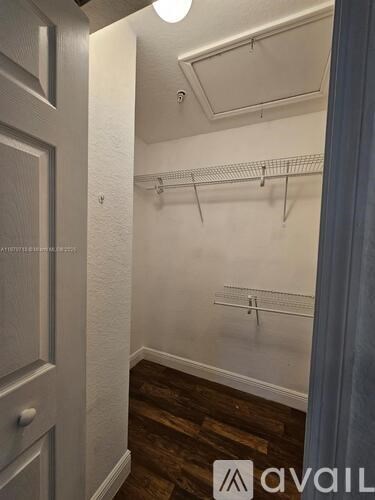 A small, empty closet with a single light fixture and a wooden floor.
