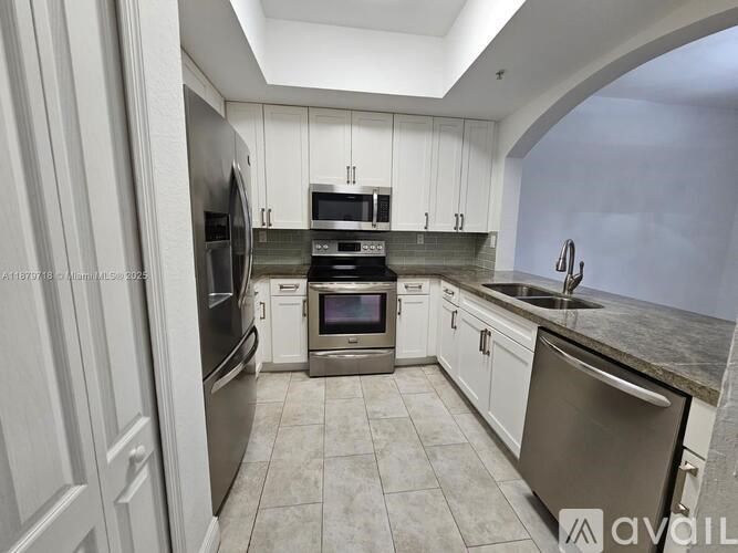 A kitchen with white cabinets and stainless steel appliances.