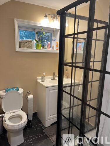 A white toilet with a blue towel on top of it.