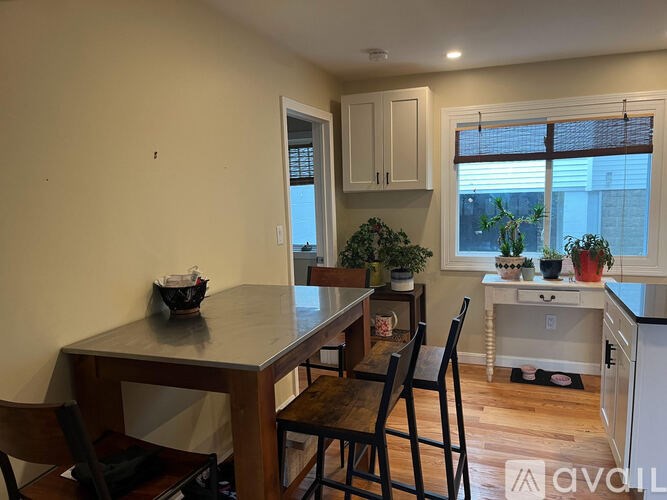 A kitchen with a table and chairs in front of a window.