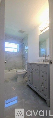 A bathroom with a toilet, sink, and mirror.